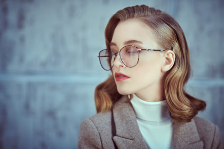 Modern young woman with beautiful blonde hair wearing elegant glasses. Beauty, fashion. Optics and...