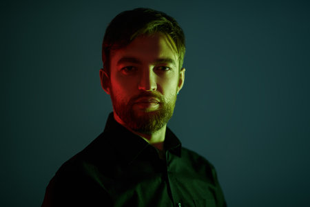 Businessman portrait. Portrait of a handsome middle aged man in black shirt in a mixed light. Men's...
