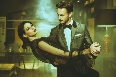 Beautiful couple in love dancing tango with passion. Evening make-up and hairstyle. Fashionable clothes.の写真素材