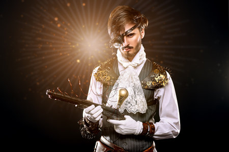 Portrait of a handsome noble man with steampunk gadgets and a gun on a black background with starlight. Steampunk concept.の写真素材