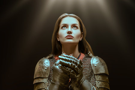 Medieval knight woman in armor prays, blessing before the battle.の写真素材