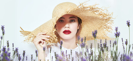Portrait of a beautiful elegant girl in a white blouse and straw hat. Summer style. Beauty and cosmetics.の写真素材