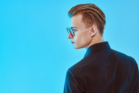 Men's accessories, optics. Portrait of a handsome young man in elegant glasses. Business style. Copy space.の写真素材