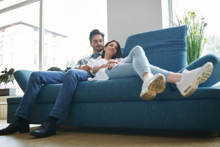 Beautiful young people in love spending time together at home. Happy couple. Home interior, furniture.の写真素材