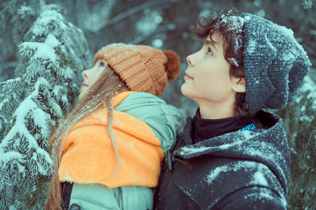 Winter holidays. Portrait of two happy young people walking in a beautiful winter park.の写真素材