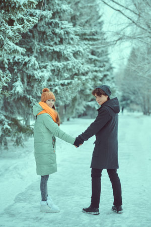 Full length portrait of two young people in love holding each other's hands. Winter season. Beauty, fashion.の写真素材