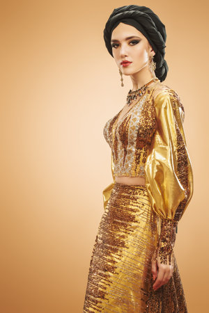 Oriental beauty woman. Portrait of a beautiful arabian woman in traditional dress, with traditional oriental make-up and black hijab. Make-up and cosmetics.の写真素材