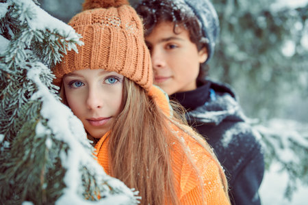 Portrait of two happy young people teenagers in a beautiful winter park. Winter holidays.の写真素材