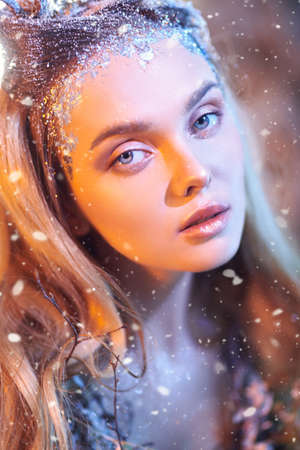 Close-up portrait of an enchanting forest nymph in a magical forest in the rays of the setting sun.の写真素材