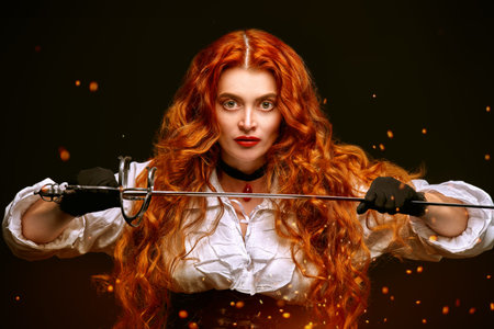 Portrait of a attractive redhead girl with a battle rapier on a black background with burning sparks...