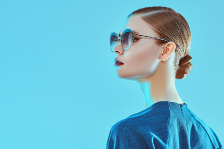 Side portrait of a beautiful young woman in elegant sunglasses. Glasses fashion. Business style.の写真素材