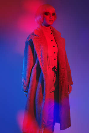 Fashion shot. Portrait of an attractive fashion model girl with bright glitter makeup and pink hair posing in fashionable fur coat. Makeup cosmetics and hairstyle.の写真素材