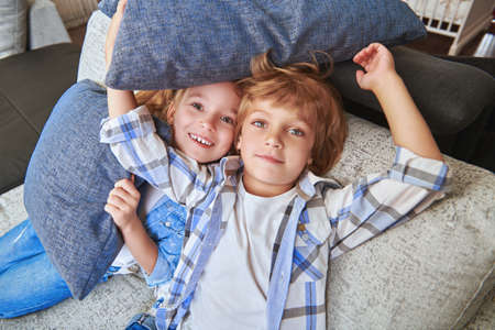Happy children playing together in a living room at home. Family concept. Happy childhood.の写真素材