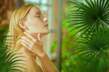 Portrait of a tropical beautiful blonde girl with fresh shining makeup with pearls. Spa, skincare and cosmetics.Beauty and jewelry.の写真素材