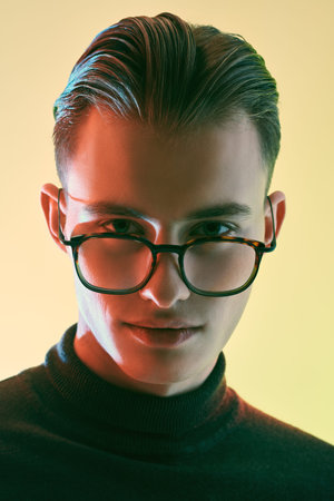 Men's accessories, optics. Close up portrait of a handsome young man in elegant glasses. Business...