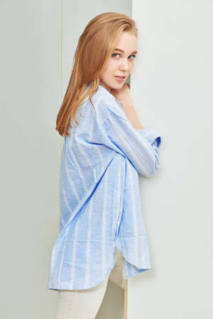 Beautiful young woman in casual clothes posing in room. Lifestyle. Home interior, furniture.の写真素材