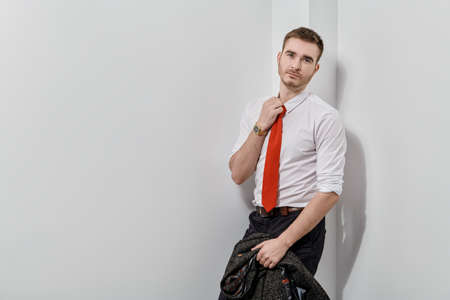 Handsome stylish man in white shirt and red tie posing on a white background. Businessman portrait.の写真素材