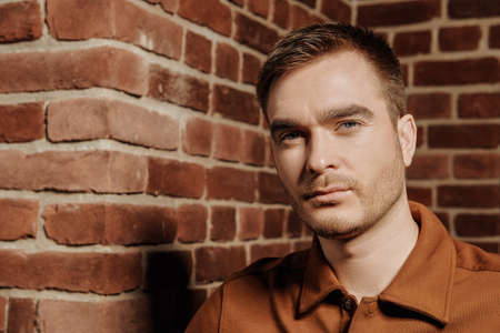 Portrait of a handsome mature man on a brick wall background. Men's beauty, fashion.の写真素材