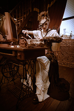 Beautiful steampunk lady scientist inventor repairs the mechanism in her laboratory with Victorian...