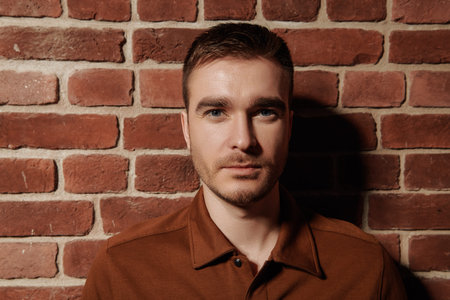 Portrait of a handsome mature man on a brick wall background. Men's beauty, fashion.