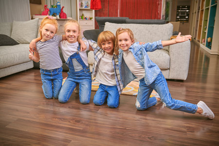 Cheerful active children are embracing in a living room.Kid's party. Happy family concept.の写真素材