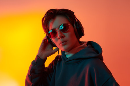 Pensive boy teenager is listening of music with headphones. Youth culture. Studio portrait in mixed...