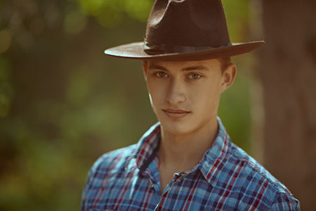 Portrait of nice young man in the wild forest. Male beauty.