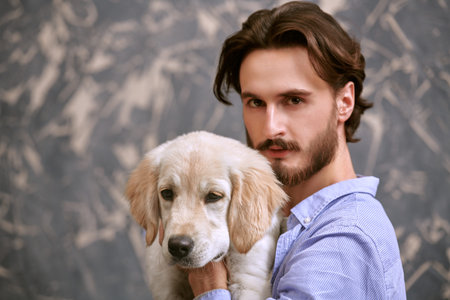 A man and a pet. Portrait of a young man hugging his Golden Retriever dog.