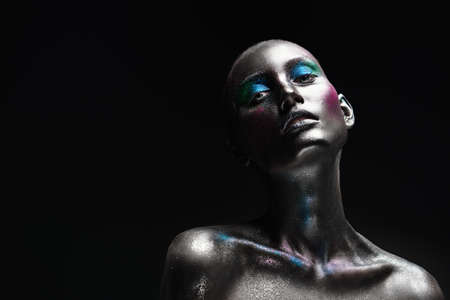 Beautiful fashion woman model with sparkling glitter makeup on black background. Makeup and cosmetics. Body art project.の写真素材