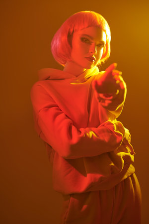 Youth fashion and beauty trends. Contemporary girl with bright makeup and wig poses in mixed color...
