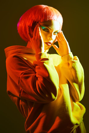 Beauty trends. Portrait of a beautiful girl with bright glitter makeup and pink hair posing in mixed...