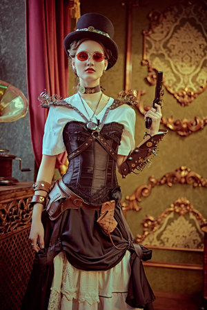 World of steampunk. Beautiful confident lady steampunk stands with a gun in a room with vintage...