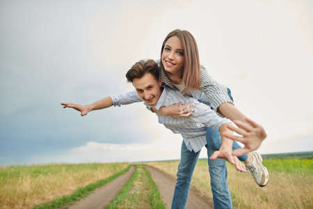 Happy romantic couple enjoying to be together in a green valley. People in love. Summertime. The spirit of freedom.の写真素材