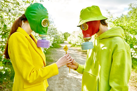 Air pollution, environmental disaster. A loving man gives a flower to his beloved woman. They wear...