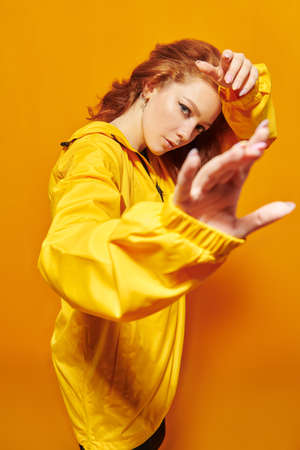Modern style dancer girl posing at studio on a yellow background.の写真素材