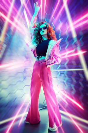 Hi-tech dance style. Beautiful young dancer girl dancing in neon light. Modern dances. Disco.の写真素材