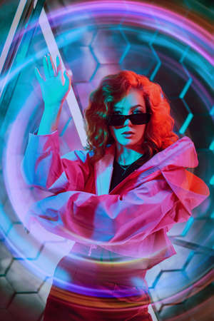 Modern dances style. Beautiful young dancer girl dancing in neon light. Hi-tech style. Disco.の写真素材