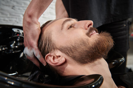 The hairdresser washes the hair of the client before the haircut. Barbershop.