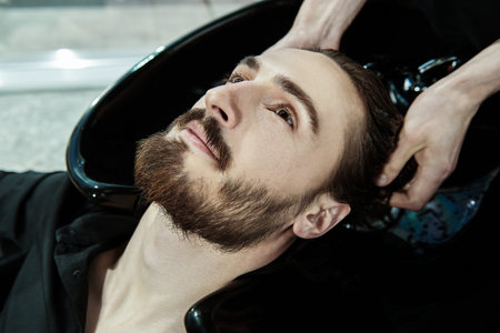 The hairdresser washes the hair of the client before the haircut. Barbershop.