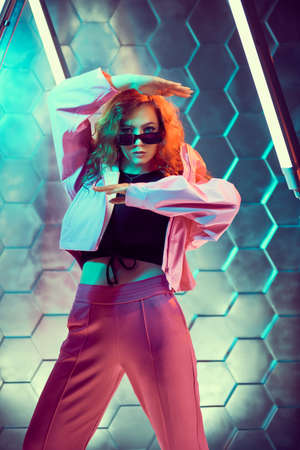 Modern dances style. Beautiful young dancer girl dancing in neon light. Hi-tech style. Disco.の写真素材