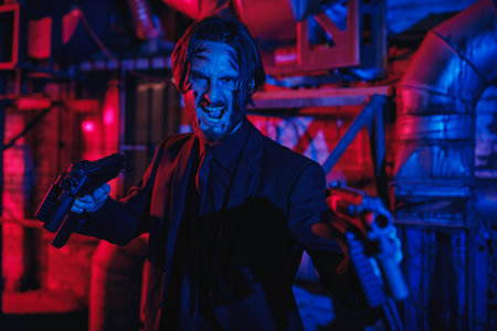 Criminal showdown. Courageous action hero with automatic guns in an industrial zone at night....
