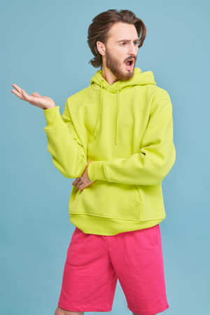 Portrait emotional attractive young man on a blue background. People, emotions. Advertising.の写真素材