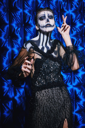 Beautiful and terrible pumpkin queen. Fashion model with skull pumpkin makeup. Halloween concept.