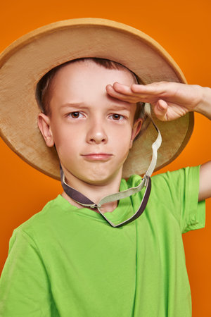 Portrait of a funny boy wearing traveler's hat and smiling at the camera. Children's dreams and...