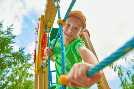 Happy boy resting and having fun on the playground in the park. Summer holidays. Happy childhood.