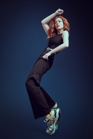 Professional modern style dancer girl dancing at studio on a dark blue background. Modern dance style.の写真素材