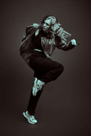 Professional ballet dancer jumping at studio on a black background. Black-and-white full length portrait.の写真素材