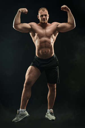 Full length portrait of a strong healthy handsome athletic man on black background. Male beauty concept. Fitness, bodybuilding.の写真素材