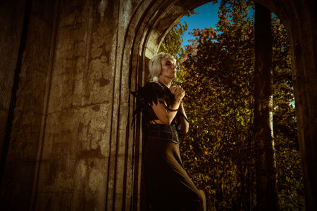 An aristocratic old widow woman with beautiful gray hair and a rich black dress stands sad in the...