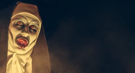 Portrait of a devilish scary nun with bloody teeth on a black background with copy space. Halloween...
